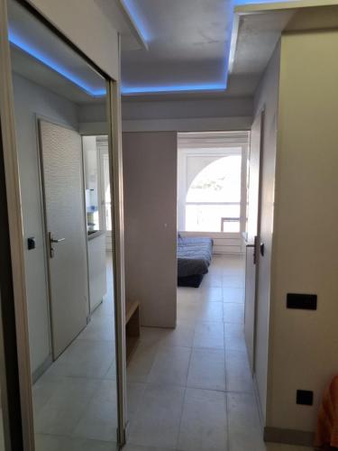 un couloir avec une chambre avec un lit et une fenêtre dans l'établissement Naturiste Cap d'Agde Port Soleil 571, au Cap d'Agde