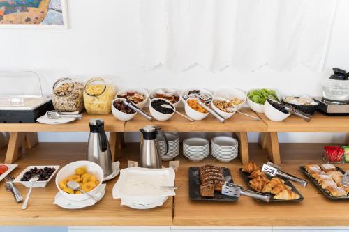 a shelf filled with lots of different types of food at Rhenia Hotel in Tourlos