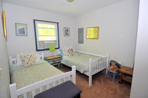 1 dormitorio con 2 camas y ventana en Cabin at Sleepy Creek - Charming Cabin, en Berkeley Springs