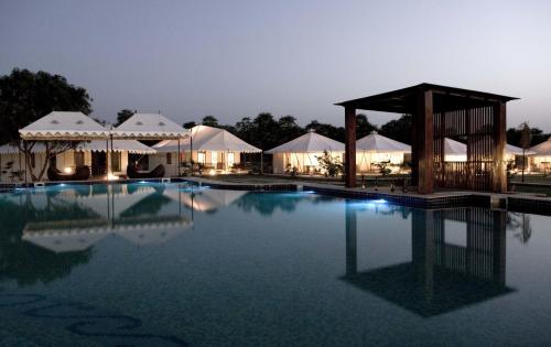 a view of a pool at a resort at night at The Greenhouse Resort in Pushkar