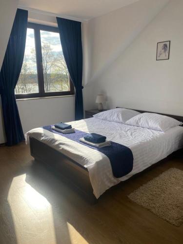 a bed in a bedroom with a large window at Dom nad Jeziorem in Sajzy