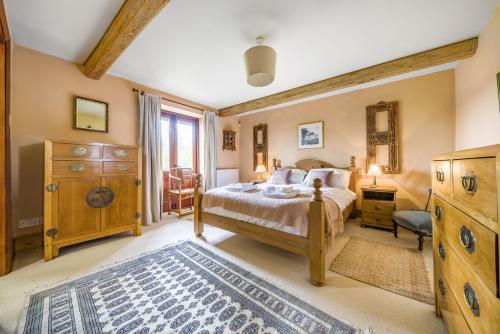 a bedroom with a bed and a dresser at The Old Piggeries in Burton Bradstock