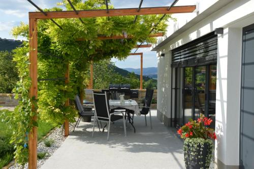 a patio with a table and chairs under a pergola at Casa Miranda - family comfort in a quiet area, near the sea, with BBQ and FREE parking in Zgornje Škofije