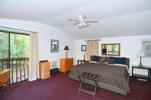 a bedroom with a bed and a ceiling fan at River Time Cabin -Time floats away! in Berkeley Springs