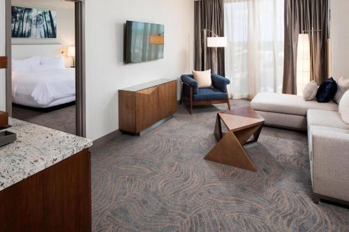 a hotel room with a king bed and a living room at The Westin Jackson in Jackson