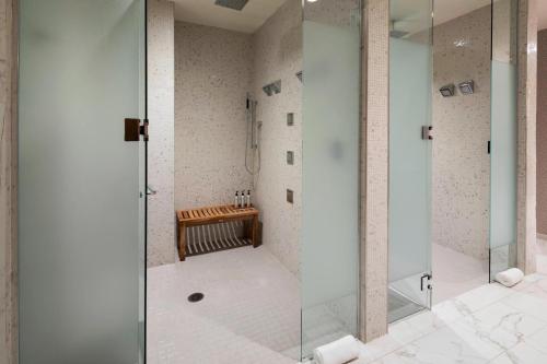 a glass shower in a bathroom with a bench at The Westin Jackson in Jackson