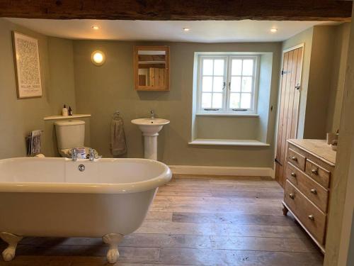 a large bathroom with a tub and a sink at Charming 3-Bed Cottage near Chipping Norton in Chipping Norton