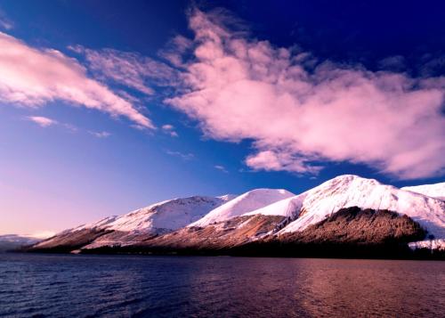 a view of snow covered mountains with a body of water at Corriegour Lodge Hotel in Spean Bridge