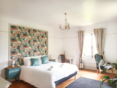 a bedroom with a large bed with a large floral headboard at Le Manoir du Cerf in Gaillon