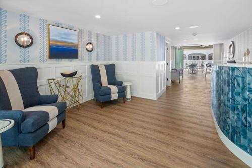 a living room with blue and white walls and wooden floors at Pelham on Earle in West Harwich