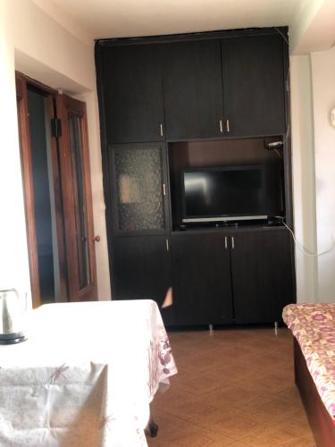 a kitchen with black cabinets and a microwave at Batumi sweet home in Batumi