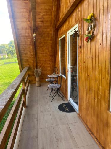 a patio with a table and chairs on a building at Cabanutze Satic in Rucăr