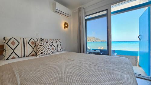 a bedroom with a bed with a view of the ocean at Blu intenso Boathouse in Firopótamos