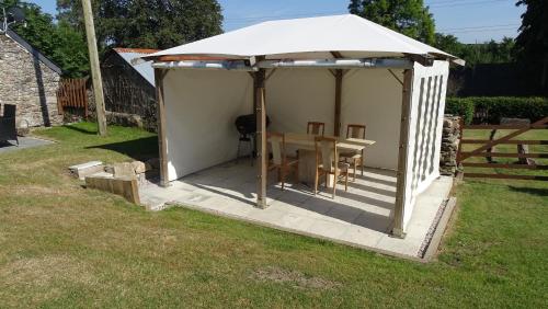a gazebo with a table and a white umbrella at The Annex at Middle Filham, Ivybridge in Ivybridge
