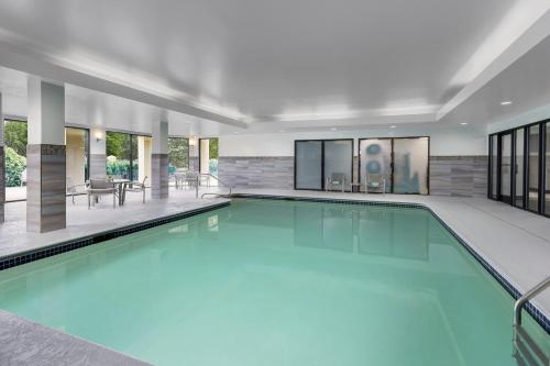 a swimming pool with blue water in a building at Courtyard Manchester-Boston Regional Airport in Manchester