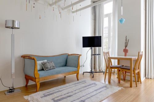 uma sala de estar com um sofá azul e uma mesa em The Art Porto - Holiday Homes no Porto