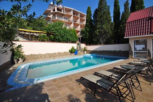 una piscina con sillas y un edificio en Ai-Todor Hotel, en Bondarenkovo