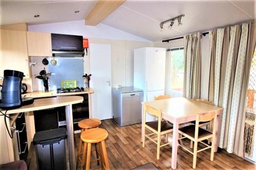 une petite cuisine avec une table et une table et des chaises dans l'établissement Mobile home 613 6 à 8 pers 44m2 tout équipé, aux Mathes