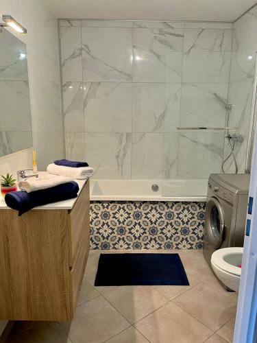 La salle de bains est pourvue d'une baignoire, d'une douche et de toilettes. dans l'établissement T2 climatisé au cœur du pôle Aéronautique,à 8 minutes de l'aéroport, à Colomiers