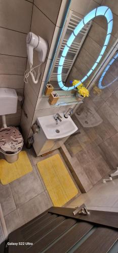 La salle de bains est pourvue d'un lavabo et d'un miroir. dans l'établissement All In Jacuzzi Apartment, à Petroşani