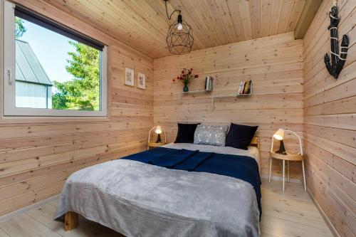 a bedroom with a bed in a wooden wall at Letnisko Lubiatowo in Lubiatowo