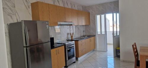 a kitchen with a stainless steel refrigerator and wooden cabinets at PIMONTAPARTMENTS in Espargos