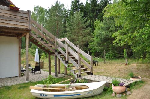 a boat sitting on the grass next to a wooden deck at Forreset in Gietrzwałd
