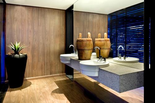 a bathroom with two sinks and a potted plant at Sia Park Executive Hotel in Brasília