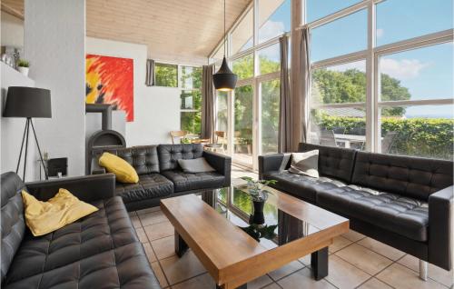 a living room with leather couches and a table at 3 Bedroom Nice Home In Sjølund in Sjølund