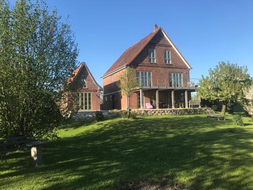 a large brick house on a grass field at Gästehaus Weidenkörbchen in Jork