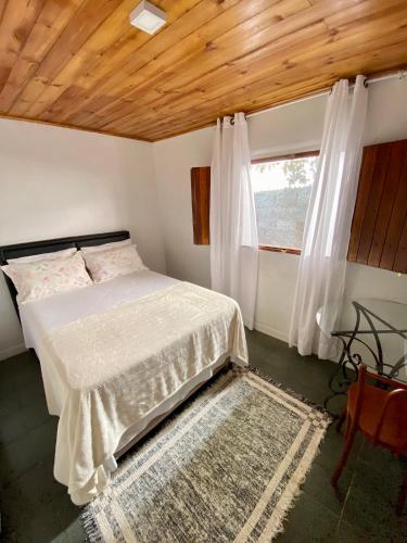 1 dormitorio con cama y ventana en Casa Jataí en Alto Paraíso de Goiás