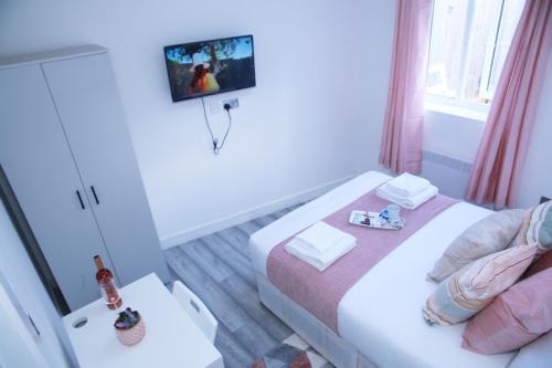 mały pokój z 2 łóżkami i telewizorem w obiekcie Harrow Luxury flat With free parking. w Londynie