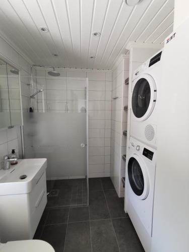 a bathroom with a washing machine and a sink at Seaside Home with Stunning Views Overlooking Blekinge Archipelago in Ronneby
