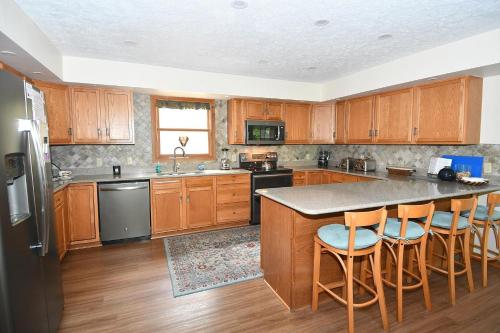 a kitchen with wooden cabinets and a island with bar stools at Healing House - Healing Escape in Berkeley Springs