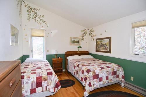 two beds in a bedroom with green and white walls at Home at Last - Gather here! in Berkeley Springs