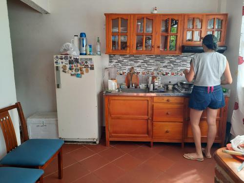 una mujer parada en una cocina preparando comida en Hostal posada San jose, en San José de Suaita