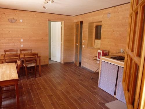 a kitchen and dining room with wooden floors and a table at Au val des meuris in Taintrux