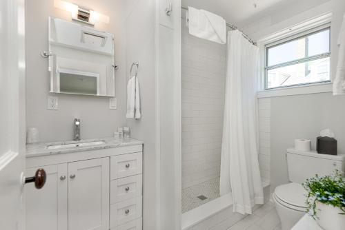Baño blanco con aseo y lavamanos en Nantucket Periwinkle, en Nantucket
