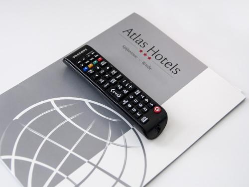 a remote control sitting on top of a book at Atlas Village Brielle in Brielle