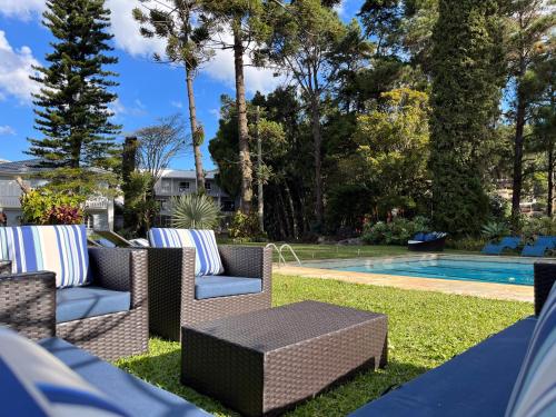 a backyard with a pool and chairs and a table at Pousada Granja Santa Barbara in Petrópolis