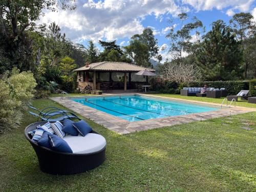 a backyard with a swimming pool and a boat in the grass at Pousada Granja Santa Barbara in Petrópolis