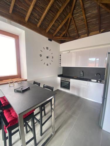 a kitchen with a table and a clock on the wall at Casa El Mirador del Almendro in Tejeda
