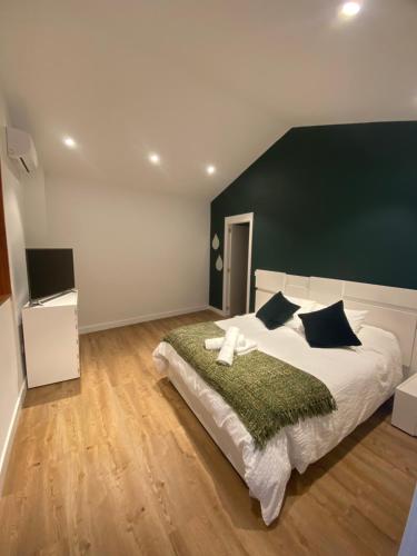 特赫達的住宿－Casa El Mirador del Almendro，一间卧室配有一张白色大床和绿色床头板