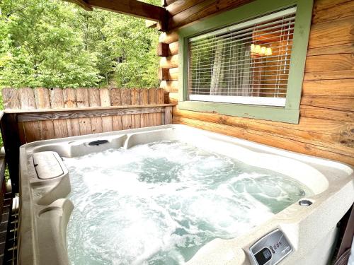 eine Whirlpool-Badewanne auf der Rückseite eines Hauses in der Unterkunft J Willy's Refuge cabin in Townsend