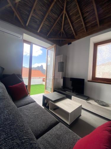 a living room with a couch and a television at Casa El Mirador del Almendro in Tejeda