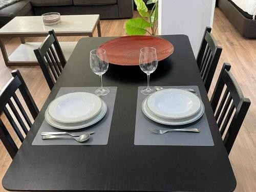 a black table with plates and wine glasses on it at Apartamento IV AlcaláRetiro Ideal Parejas in Madrid