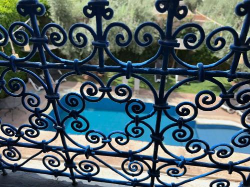 an iron gate with a pool behind it at Oasis Merasi Marrakech in Marrakech