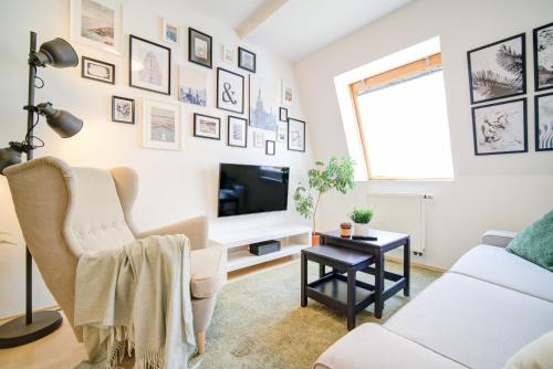 a living room with a white couch and a tv at Residence Caesar by Homester in Brno