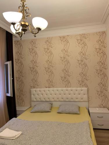 1 dormitorio con cama y pared con papel pintado en Old Batumi Apartments, en Batumi