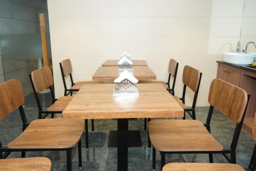 a dining room with wooden tables and chairs at HOTEL OM INN in Gandhinagar